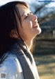 A woman with long black hair and a gray scarf.