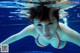 A woman in a red bikini swimming in a pool.