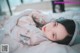 A woman laying on top of a bed covered in plastic.